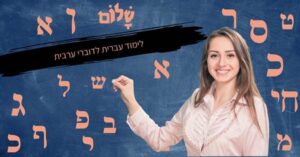 תמונה של מורה מחייכת מול לוח עם אותיות עבריות—לימוד עברית לדוברי ערבית באופן פשוט ונגיש